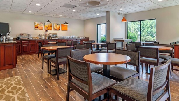 A modern restaurant with a central counter, multiple seating areas, and large windows providing natural light. - Comfort Inn & Suites Dahlonega University Area (Dahlonega)