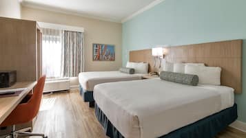Habitació d'hotel amb dos llits, un escriptori i una cadira.
