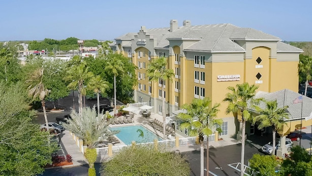 A hotel with a pool, outdoor seating, and a sign for 'Galleria'.
