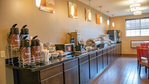 Una barra larga con dispensadores de café, una máquina de café y un dispensador de bebidas.