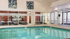 A swimming pool with exercise equipment, glass doors, and artwork on the walls. - Hampton Inn & Suites Rochester/Victor (Victor)