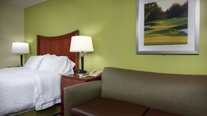 A hotel room with a bed, a desk with a lamp, a telephone, and a framed picture on the wall. - Hampton Inn Franklin (Franklin)