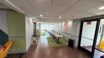 A hotel lobby with a long corridor, seating area, and an exit door.
