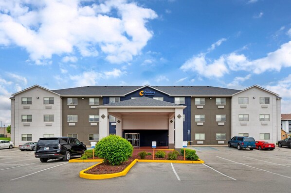 A Comfort Inn hotel with a parking lot, multiple cars, and a clear sky. - Comfort Inn & Suites North Greenfield (Greenfield)
