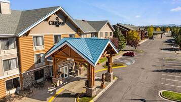 Clubhouse Inn con entrada cubierta, mesas al aire libre y estacionamiento.