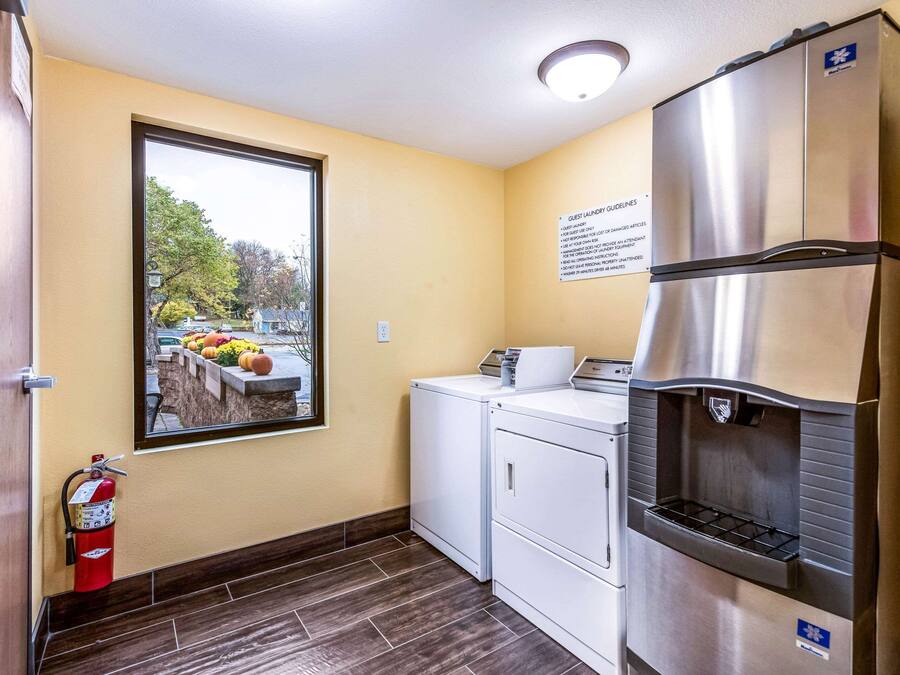 A compact laundry area with a washing machine, dryer, and a water fountain.