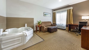 A hotel bathroom with a large bathtub, a sofa, a desk, and a chair. - Comfort Suites Omaha East-Council Bluffs (Council Bluffs)