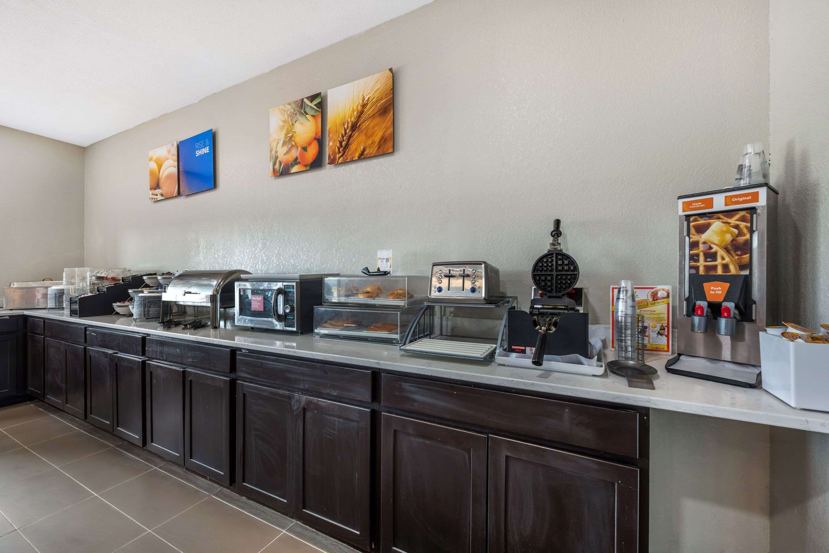 Ein Frühstücksbuffet mit Kaffeemaschine, Toaster und Speisenauslage.