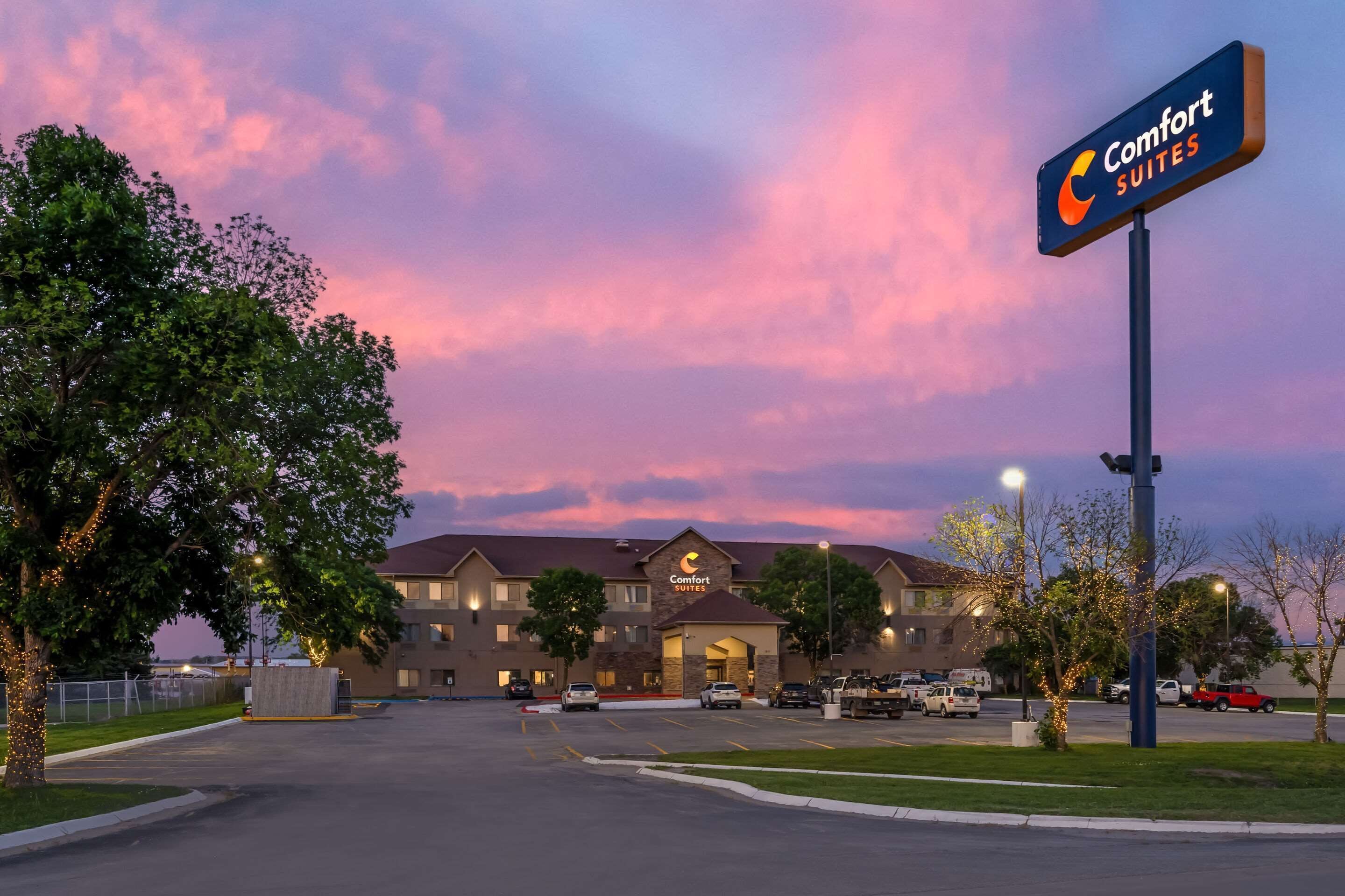 Un hotel Comfort Suites con estacionamiento y un letrero grande.