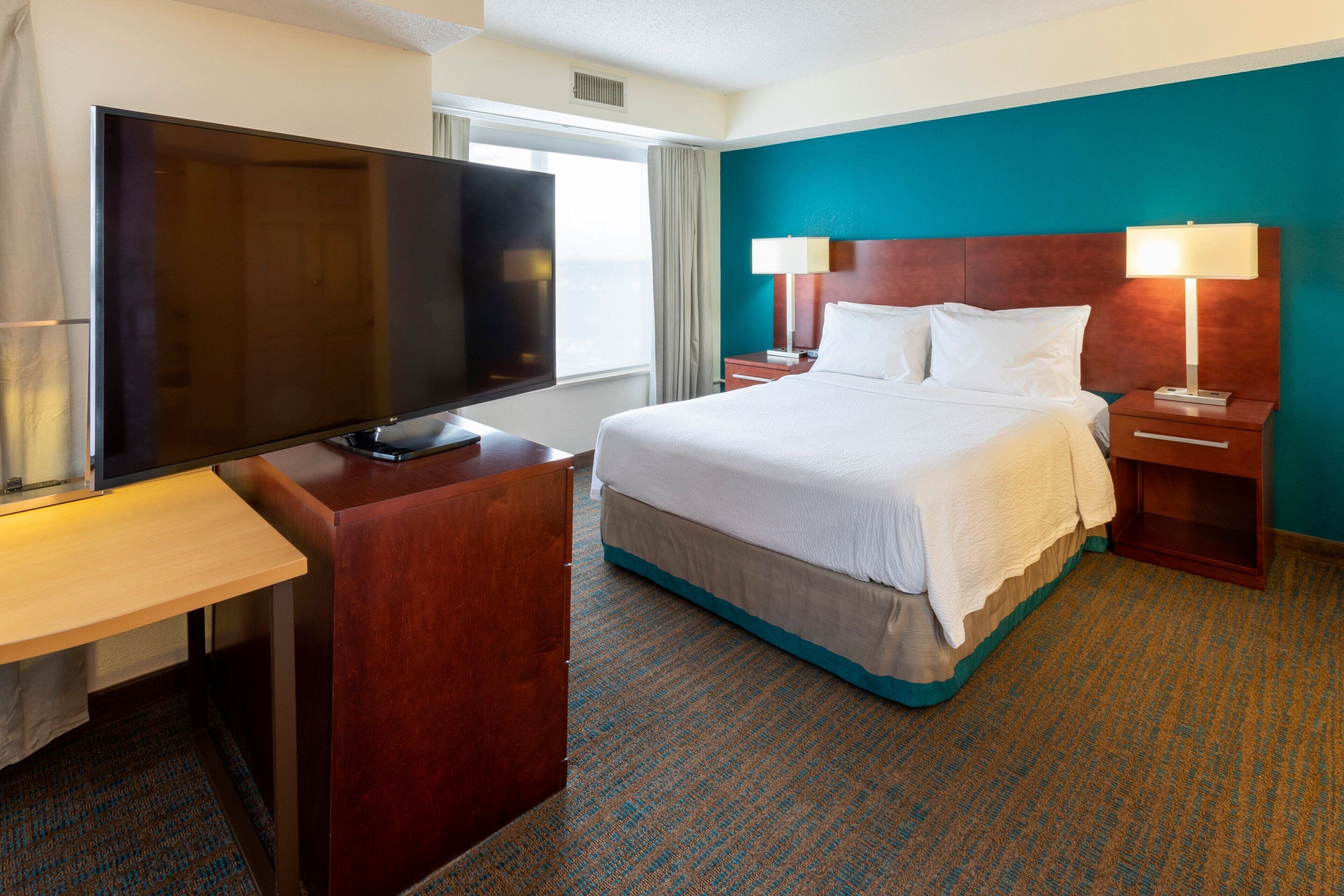 أغطية فراش متميزة وخزنة داخل الغرفة ومكتب ومساحة عمل للكمبيوتر المحمول