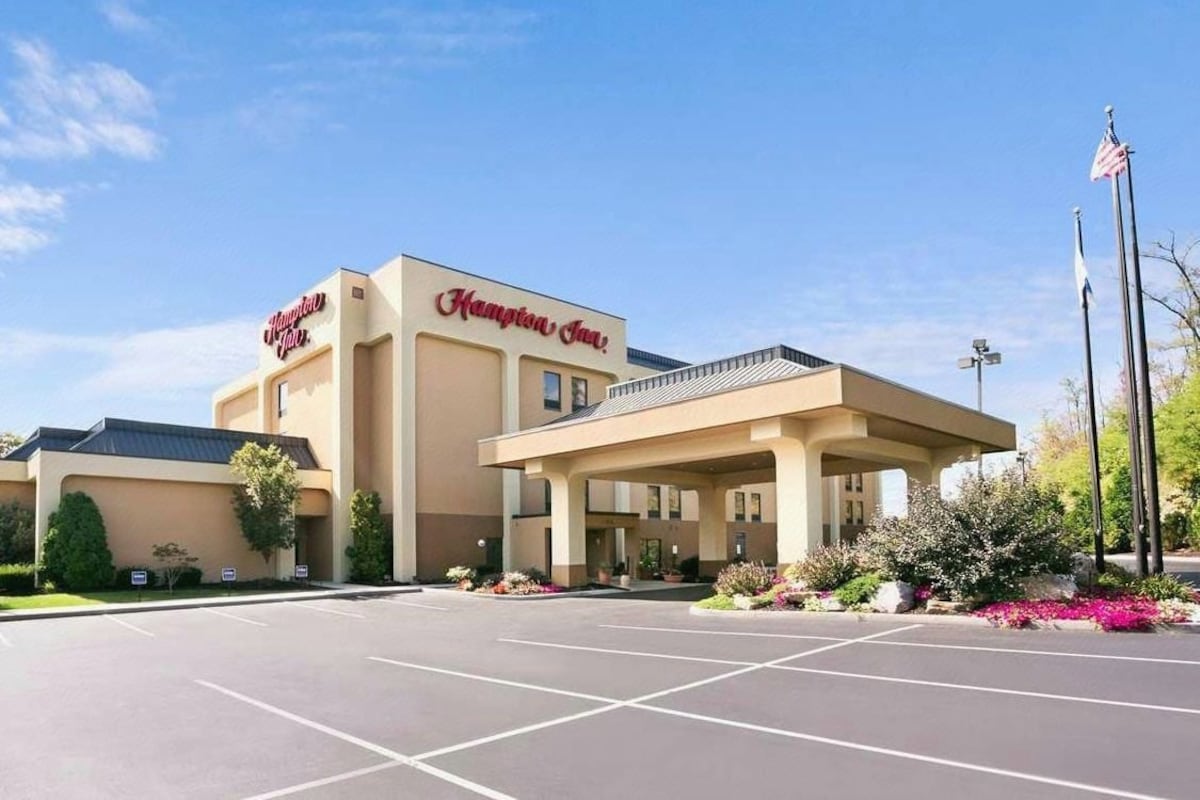 Hotel Hampton Inn con estacionamiento y un área exterior techada.
