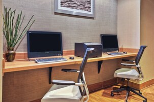 A workspace with two Lenovo monitors, a keyboard, and two office chairs.