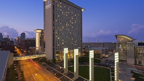 A high-rise hotel with a modern design, featuring a prominent 'HYATT' sign, multiple floors, and a well-lit facade. - Hyatt Regency McCormick Place Chicago    (Chicago)
