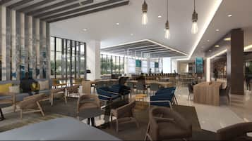 Un hall d’entrée spacieux, doté de sièges modernes, de grandes fenêtres et d’un plafond haut.
