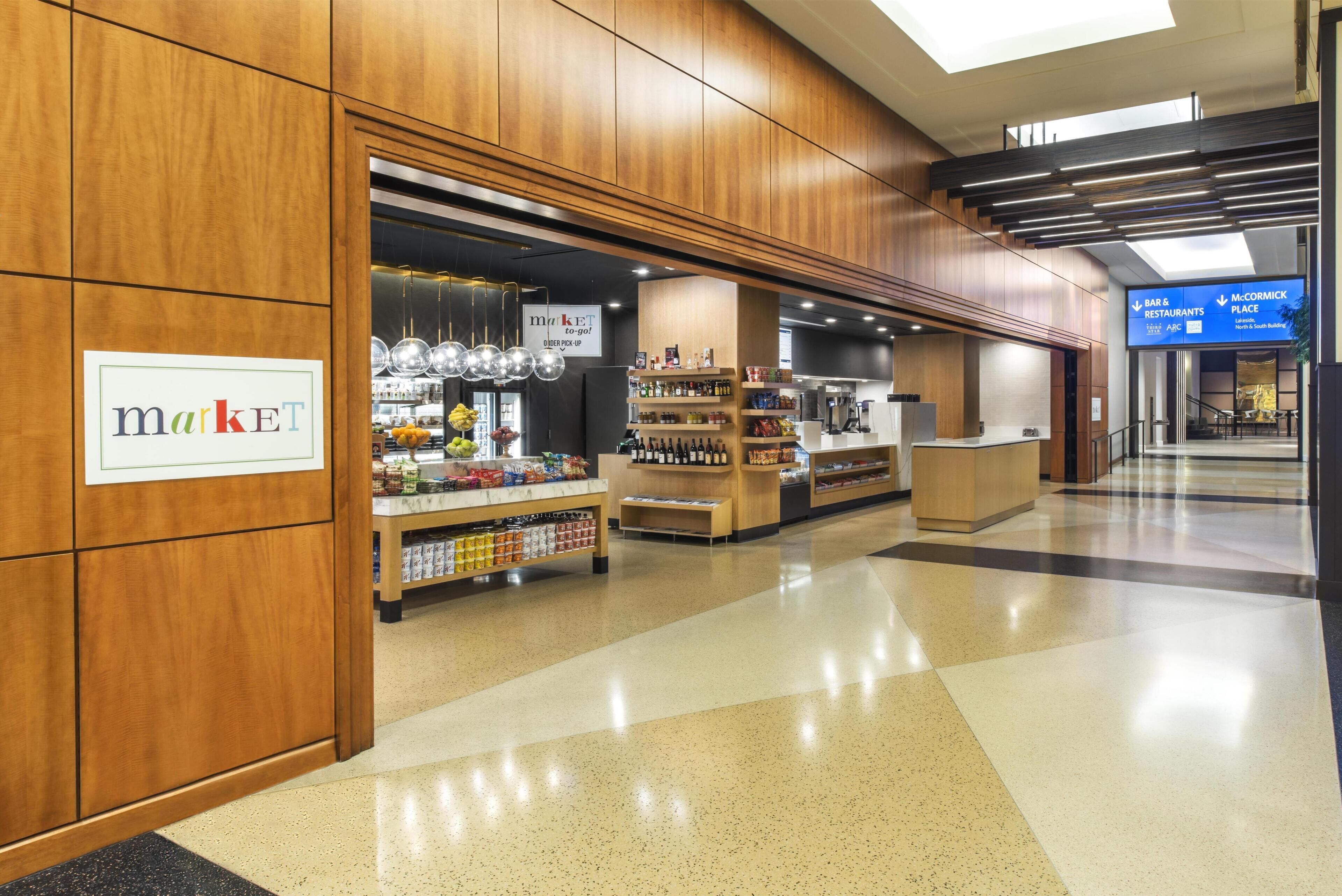 A market area with shelves stocked with various products, a sign indicating a market, and a McCormick Place sign in the background.