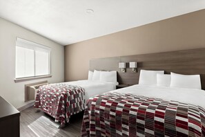 Une chambre d’hôtel avec deux lits, une grande fenêtre et une tête de lit moderne.