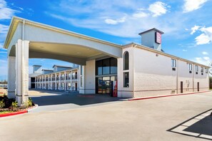 Un hôtel doté d’une entrée couverte, d’un auvent rouge et d’une enseigne indiquant la présence d’un restaurant Red Roof.