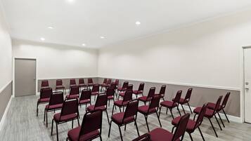 A conference room with rows of chairs and a door.