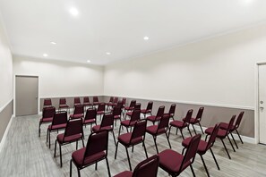 Una sala de conferències amb files de cadires i una porta.