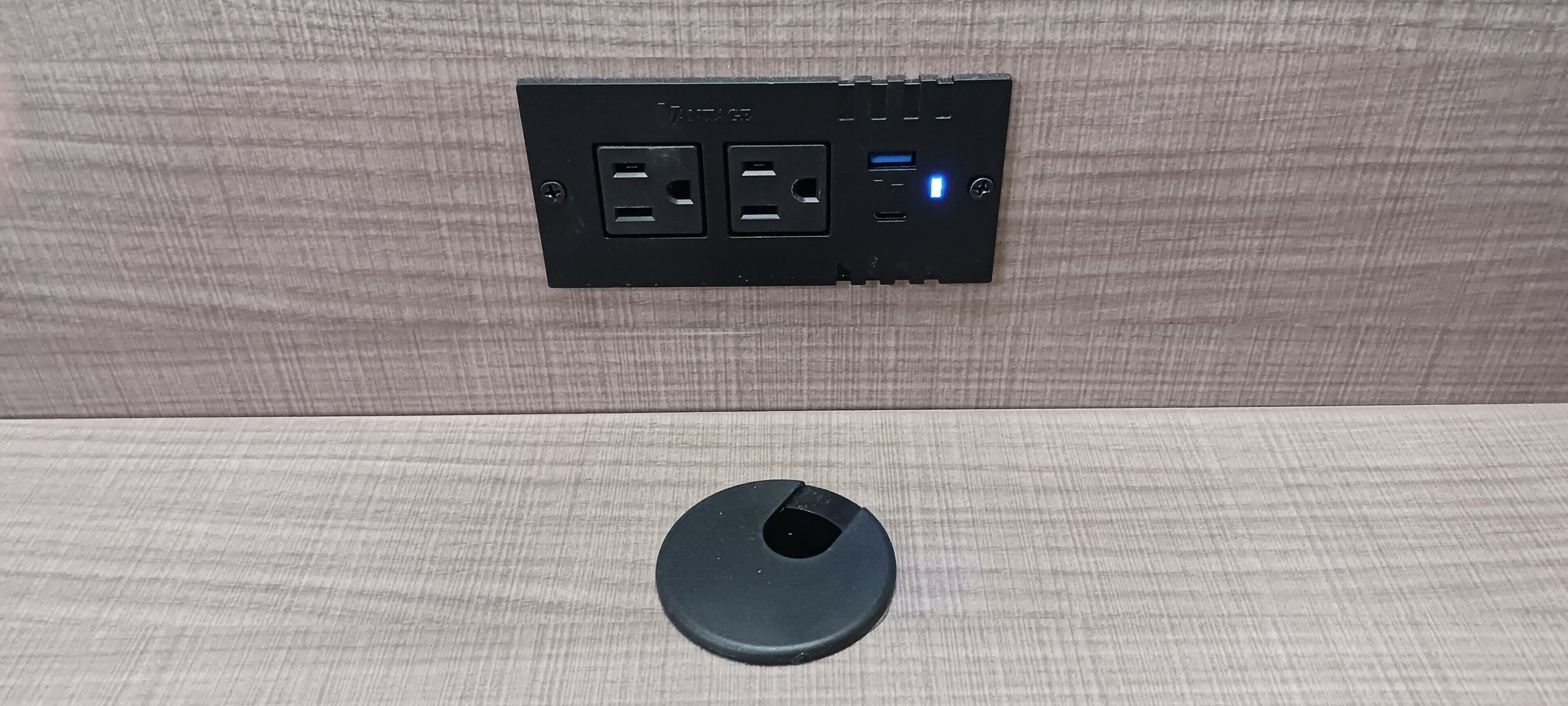 Une multiprise dotée de plusieurs prises et de ports USB, fixée sur un mur à texture.