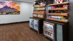 Un présentoir rempli de divers aliments emballés et un réfrigérateur contenant des boissons.