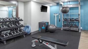 A gym with dumbbells, a bench, a medicine ball, and a pull-up bar.