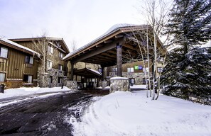 A building with a covered entrance, stone walls, and snow-covered surroundings. - Holiday Inn Express Hotel & Suites Park City by IHG (Park City)
