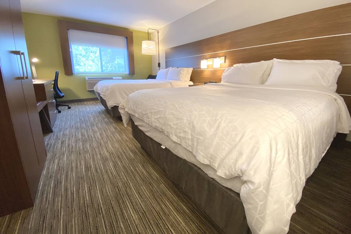 Una habitación de hotel con dos camas, un escritorio y una silla.