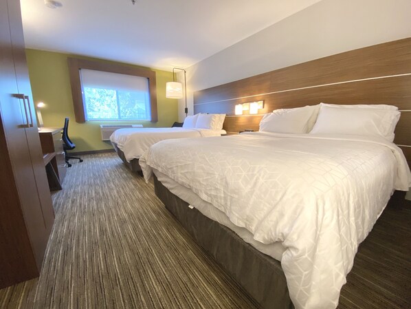 Una habitación de hotel con dos camas, un escritorio y una silla.