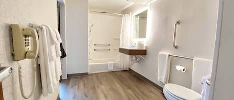 Un baño de hotel con bañera, inodoro y teléfono.