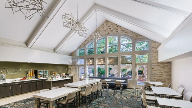 A spacious room with a high ceiling, large windows, and a modern kitchen area. - Residence Inn by Marriott Gaithersburg Washingtonian Center (Gaithersburg)