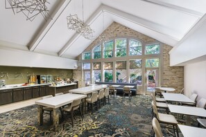 A spacious room with a high ceiling, large windows, and a modern kitchen area. - Residence Inn by Marriott Gaithersburg Washingtonian Center (Gaithersburg)