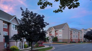 A residential building with a red brick facade, large windows, and a well-maintained lawn. - Residence Inn by Marriott Gaithersburg Washingtonian Center (Gaithersburg)