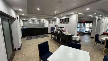 A modern reception area with a 'Welcome to the Volunteer State' sign, a counter, and a buffet with various food items.