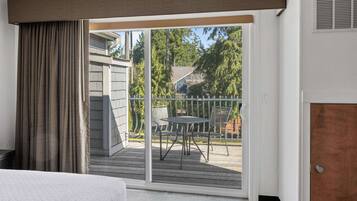 A room with a sliding glass door leading to an outdoor deck with a table and chairs.