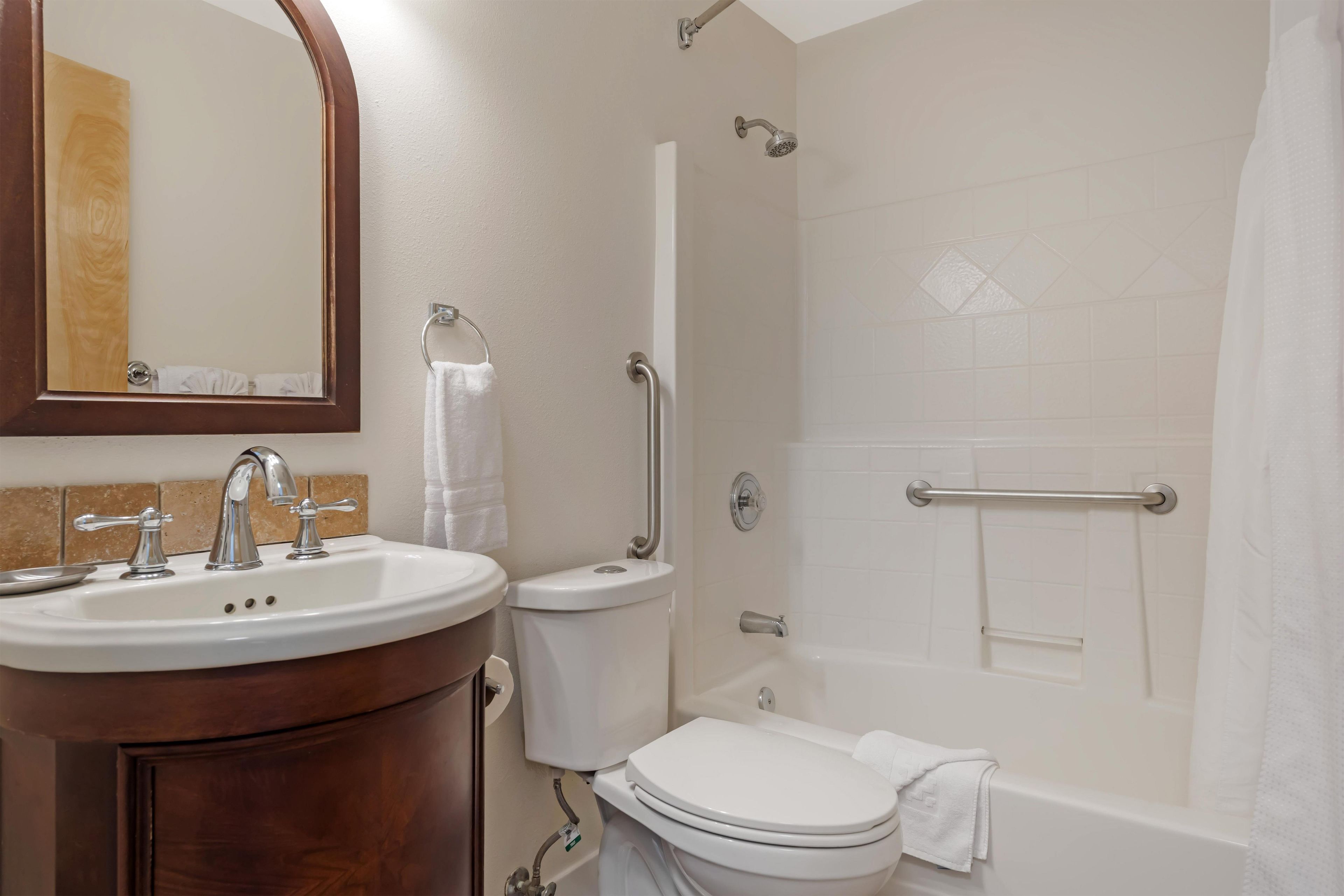 Un baño con lavamanos, inodoro y ducha.