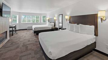 Een hotelkamer met twee bedden, een bureau, een stoel en een televisie.
