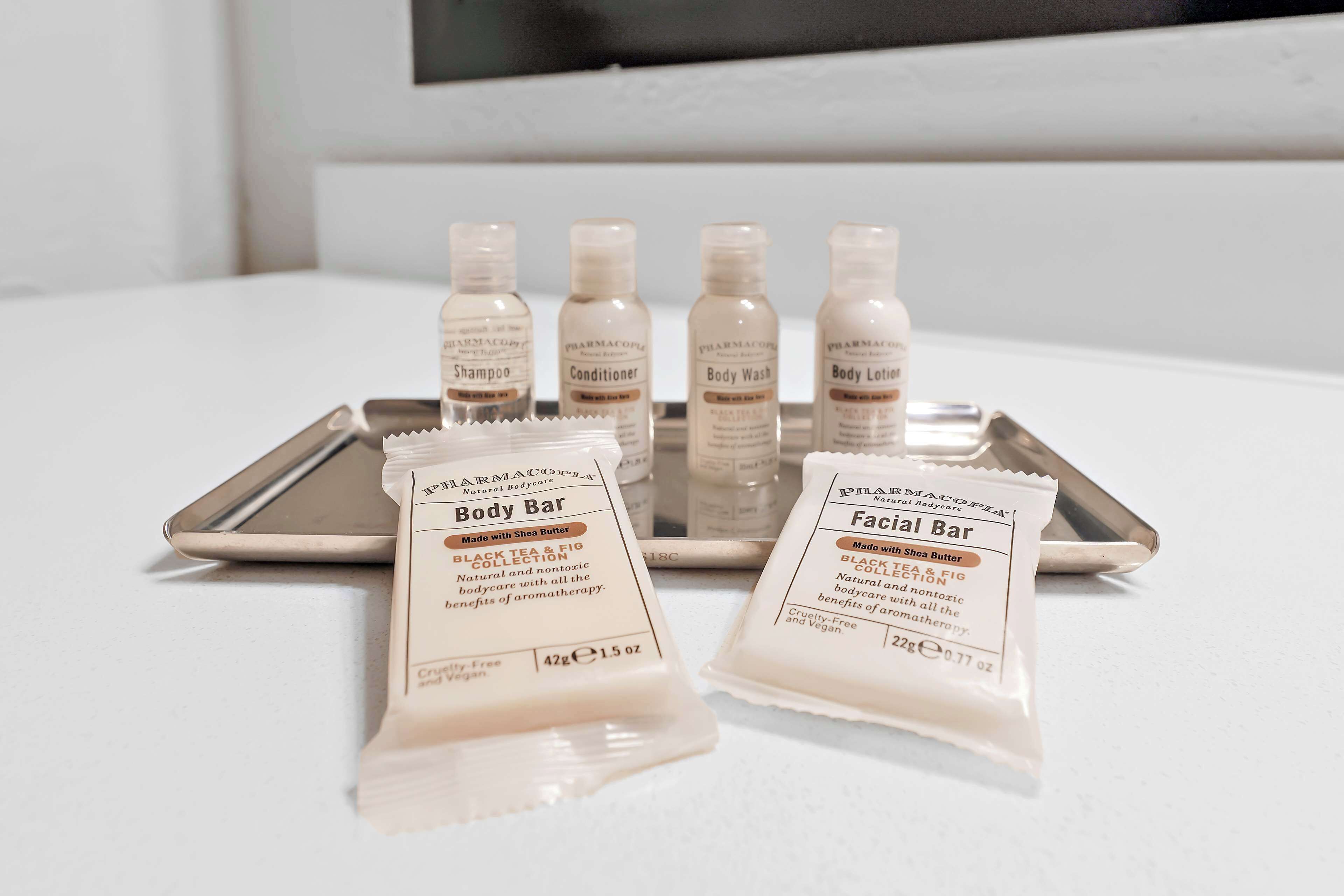 A tray with body and facial bar products, including shampoo, conditioner, body wash, and lotion.
