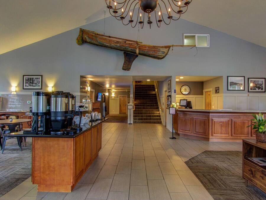 A spacious kitchen with a central island, wooden cabinets, and a chandelier.