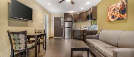 A modern kitchen with dark wooden cabinets, a stainless steel refrigerator, and a built-in oven.