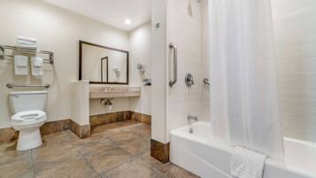 A modern bathroom with a toilet, sink, mirror, shower, and bathtub.