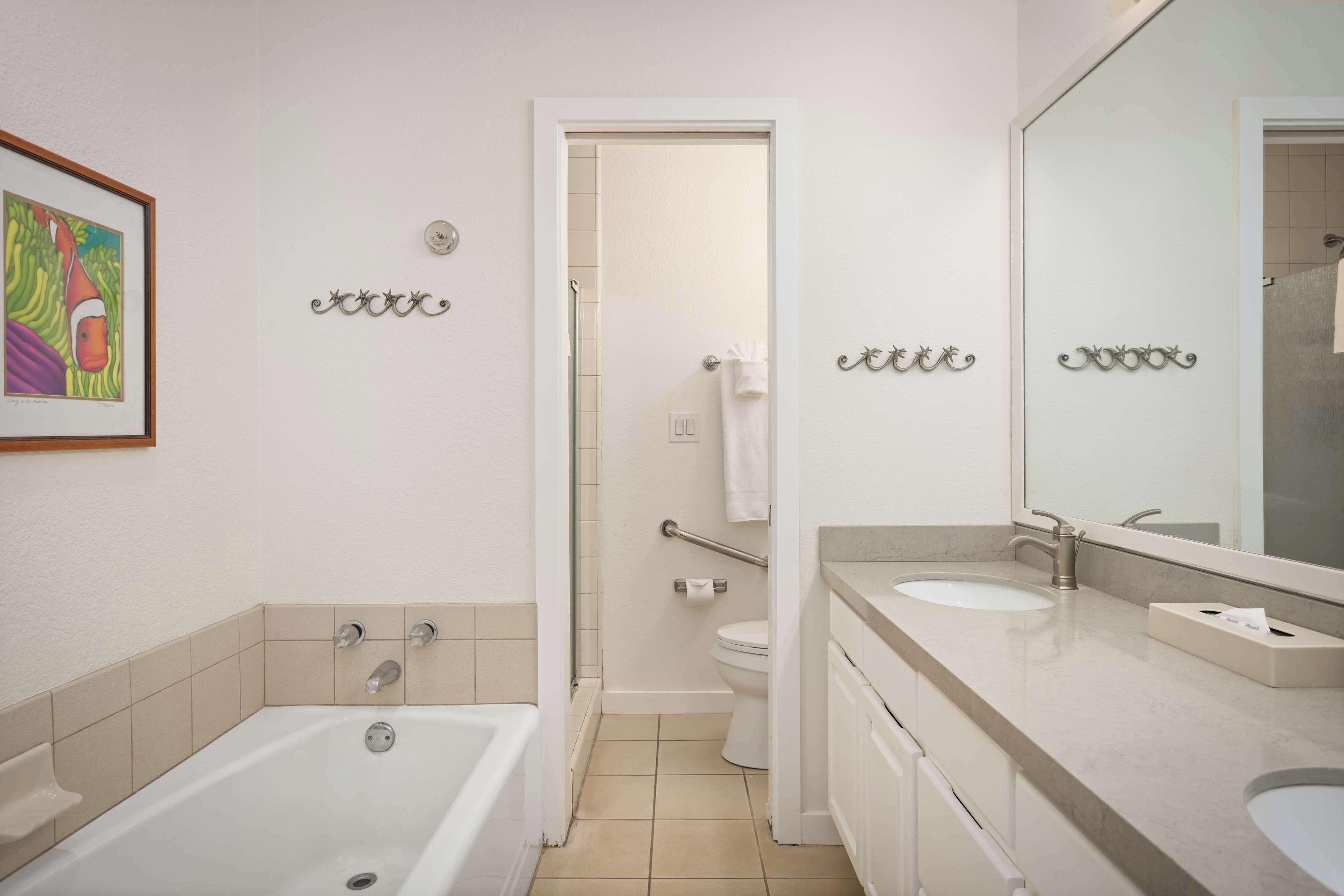 Ein Badezimmer mit einer Badewanne, zwei Waschbecken, einer Toilette und einer Dusche.