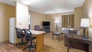 A hotel room with a desk, two office chairs, a television, a sofa, a lamp, and a window with curtains. - Extended Stay America Austin Metro (Austin)