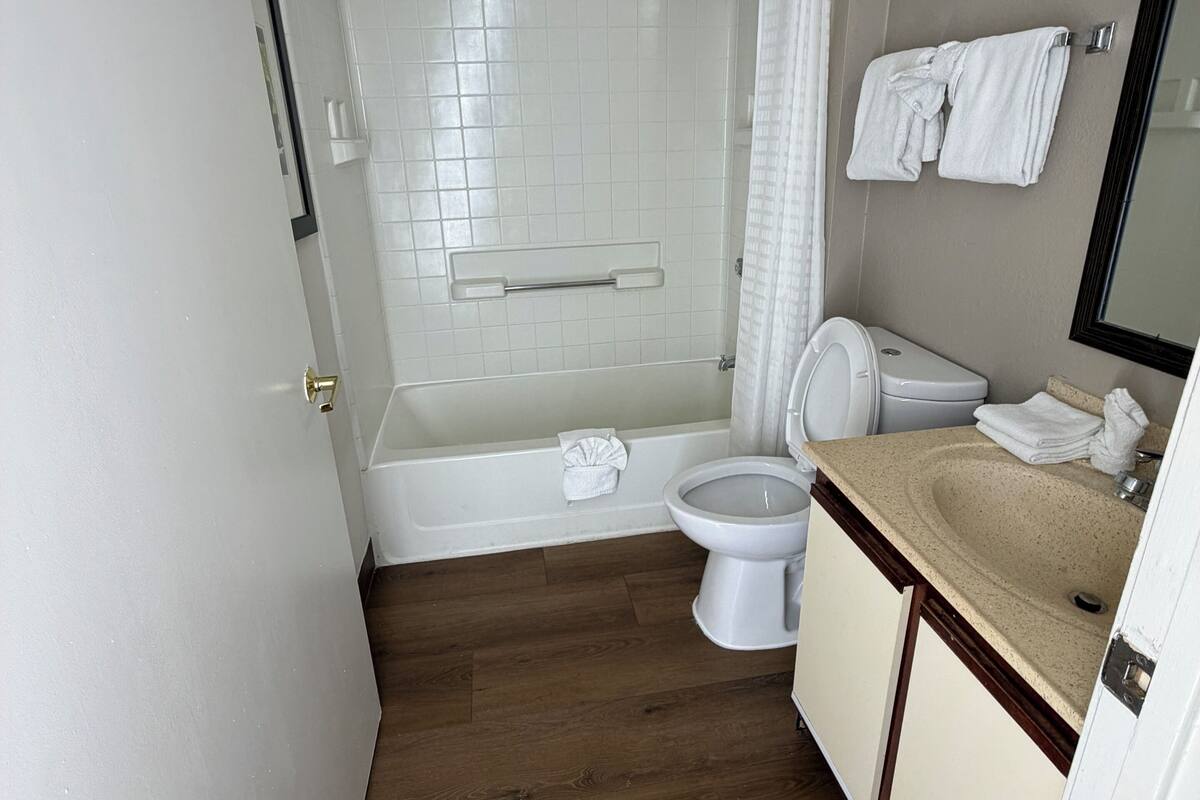 A bathroom with a bathtub, toilet, and sink.