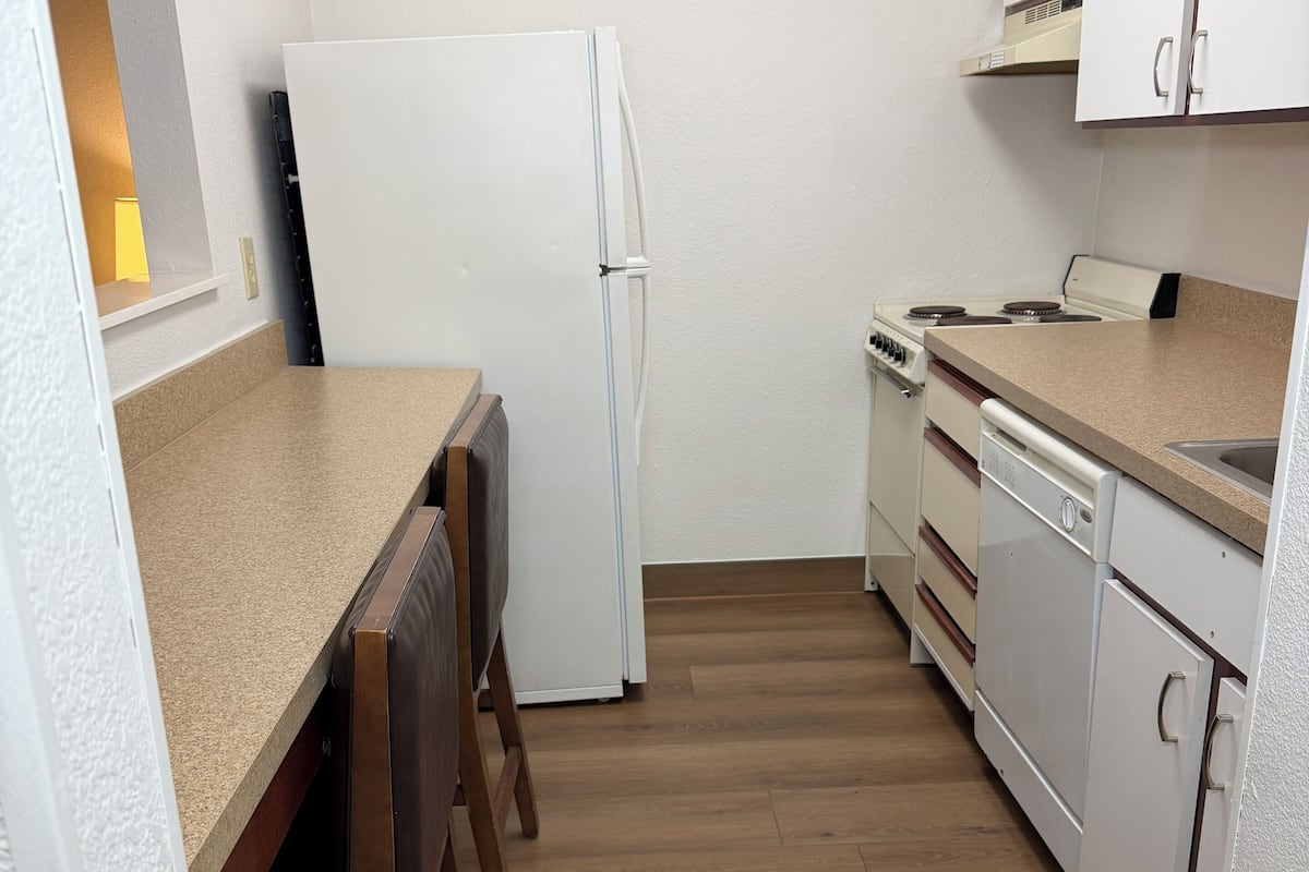 A compact kitchen with a refrigerator, stove, and dishwasher.
