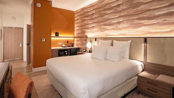 Une chambre d’hôtel avec un grand lit, des tables de chevet, un bureau et une salle de bain.