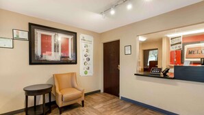 A reception area with a reception desk, a framed picture, a chair, and a small table. - Extended Stay America Select Suites Roanoke Airport (Roanoke)