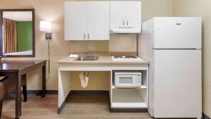 A compact kitchenette with white cabinets, a sink, a microwave, and a refrigerator. - Extended Stay America Select Suites Roanoke Airport (Roanoke)