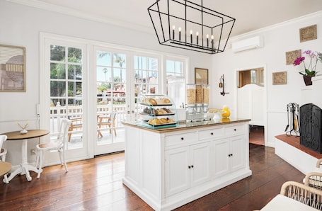 A bright kitchen with a large island, white cabinetry, and a view through glass doors to an outdoor patio.