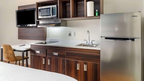 A compact kitchenette with a microwave, refrigerator, and a small sink. - Suburban Studios LaVale-Cumberland (Cumberland)